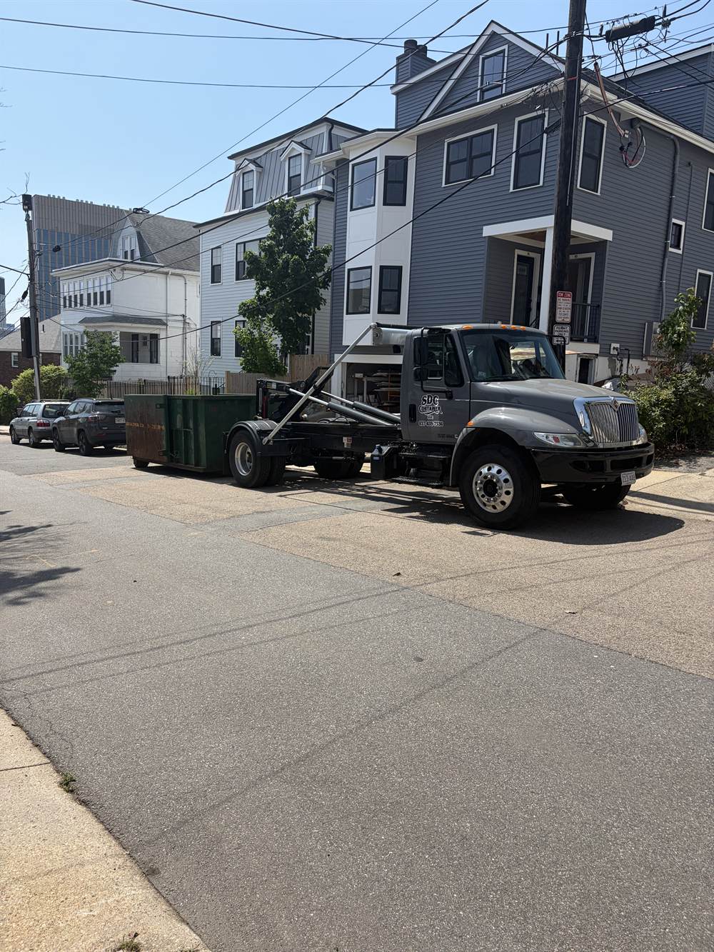 An SDC Container roll-off set on a residential street in Massachusetts during a renovation